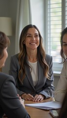 Smiling adult woman in a grey suit engaging in a professional business meeting with colleagues, collaboration concept.
