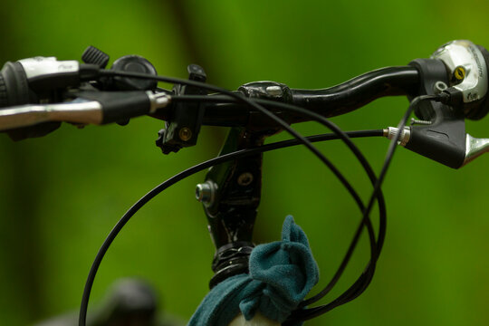 Closeup of bicycle handlebars showcasing intricate cables, an important bell, and a comfortable grip, highlighting key components for riders enjoying various biking adventures - Powered by Adobe