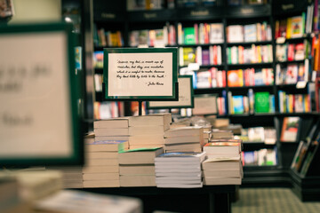 Handwritten Jules Verne quote about science and truth on bookstore sign displayed over stack of...