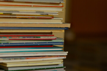 A collection of various magazines, journals, and books stacked neatly on top of each other, showcasing a variety of striking cover designs and vibrant colors that attract attention