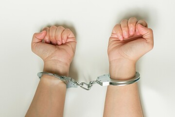 Hands in handcuffs isolated on white background. Concept of arrest, crime, punishment, law...