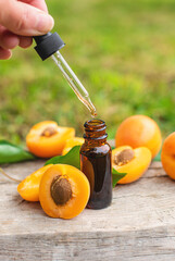 Apricot essential oil in a bottle. Selective focus.