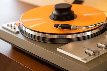Vintage Stereo Turntable Record Player With Colored Disk and Weight Clamp Sitting on Wooden Console...