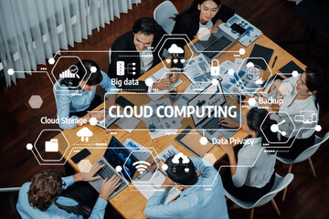 Diverse team members actively collaborating on cloud computing strategies with digital tools and visual aids in a contemporary office setting. Amity