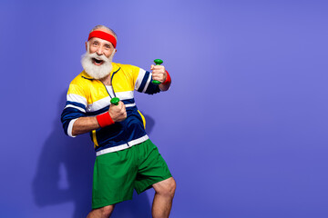 Energetic elderly man in vibrant retro workout attire posing against a colorful background, embracing fitness and a joyful lifestyle