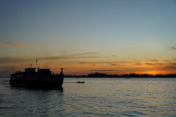 Silhouette of a Boat on Calm Water at Sunset