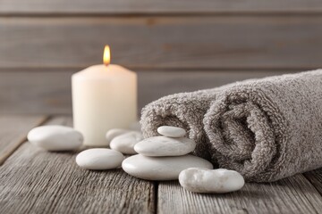 Spa scene with candle, stones, and towel
