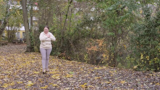 Middle aged woman Woman jogging in nature, suddenly stops, holds chest in pain, fitness danger, medical emergency, sudden cardiac symptom