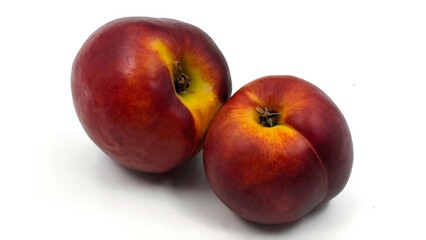 Photo of two ripe, nectarines (also known as flat or doughnut nectarines), isolated on white background.