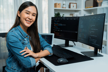 Young Asian in IT developer looking at camera to present with online information on pc with coding...