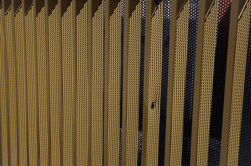 Yellow metal grille along an overpass. Shadow play, image taken with zoom lens, graphic effect.