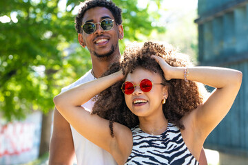 young latin couple smiling happily, laughing