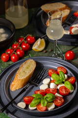 Caprese salad with tomatoes, mozzarella, basil, and bruschetta on a rustic table setting