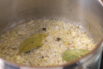 Chopped onions are fried with spices in a pot for preparing goulash