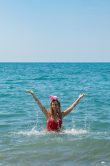 Santa Hat Serenity: Girl in Red Swimsuit Swimming in the Sea