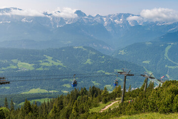 Hiking above the clouds on Wankberg, Germany—panoramic views of snow-capped Alps and lush valleys under a bright blue sky.