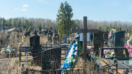 Gravestones at a quiet cemetery honor the memory of loved ones, symbolizing faith, resurrection,...