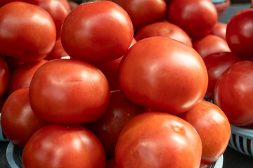 Vibrant red tomatoes symbolizing the essence of life and growth. Fresh tomatoes on display at a bustling market, inviting a taste of summer.