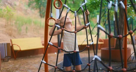 Child Climbing Rope Structure in Outdoor Playground - Powered by Adobe