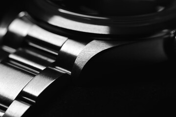 Detailed black-and-white macro shot of a metallic watch bracelet