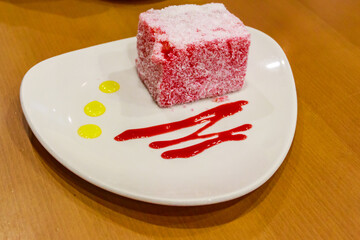 Piece of pink cake Pasta Roza on wooden table