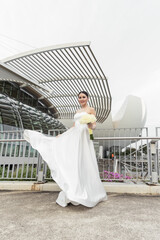 Smiling bride in elegant dress with futuristic minimalist city architecture in background