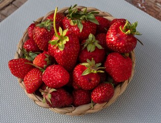 Fresh organic strawberries with natural blemishes in a wicker basket