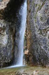 water of waterfall in the rocks of mountains in the european alps
