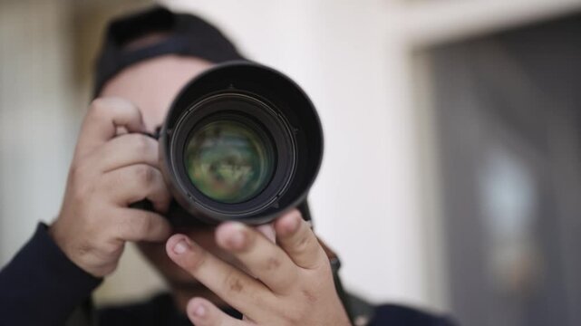 Professional photographer capturing photos using a mirrorless camera with focus on the prime lens
