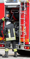 firefighters in protective helmets and uniform unroll fire hose hose during emergency management