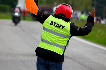 security staff person with yellow vest with the text who reports problems