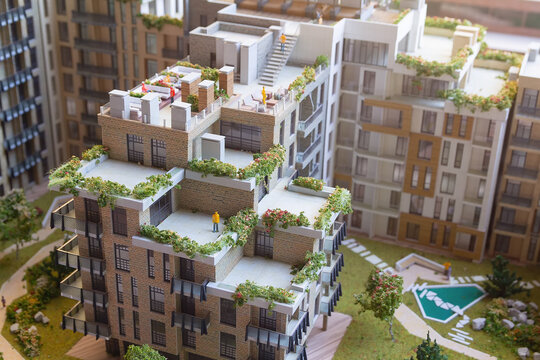 Building a model of modern housing with gardens light burning on the table. Architecture