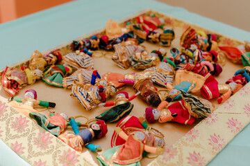 Handmade colorful dolls on a decorative tray, showcasing cultural crafts and traditional artistry....