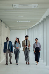 Business people walking and talking in office hallway