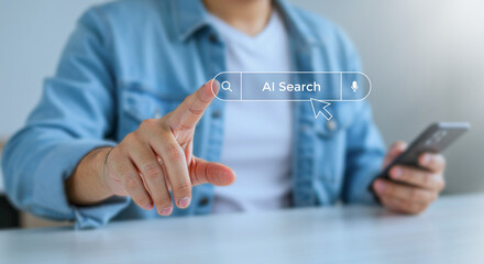 Photo of a finger hovers over an ai search bar, a smartphone held in hand, suggesting a seamless blend of technology and human interaction