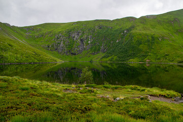 Fototapeta premium Peaceful Mountain Lake Reflection at Skottenvannet on the Trail to Sjurvarden, Norway