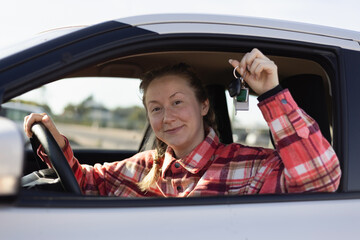 Woman Holding Car Keys Sitting Behind Steering Wheel