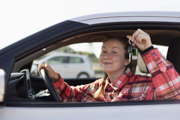 Woman Holding Car Keys Sitting Behind Steering Wheel