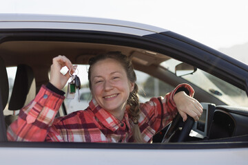 Woman Holding Car Keys Sitting Behind Steering Wheel