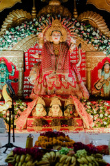 Elaborate Hindu deity display, adorned with flowers and intricate details, presents a vibrant cultural and religious art form.