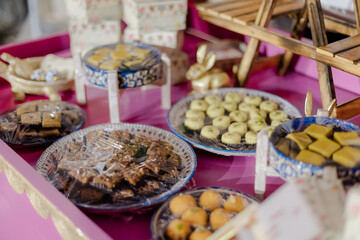 Assorted sweets and snacks arranged on a vibrant pink surface, showcasing a variety of flavors and textures under clear wraps.