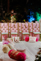 Elegant seating arrangement for a special event. Chairs are draped in pink fabric, complimented by...