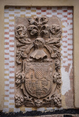 Noble coat of arms sculpted in stone located on the exterior wall of a house