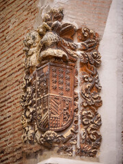 Noble coat of arms sculpted in stone located on the exterior wall of a house