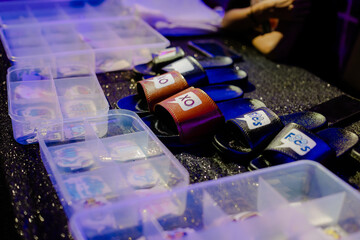 Assorted slide sandals on a table. Customization accessories are arranged in a clear box, ready for personalization and event giveaways.