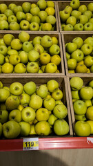 Fresh green apples in wooden crates at a grocery store, bright yellow-green, showcasing their freshness and quality.