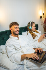 Modern Couple in Bed – Separate Digital Worlds, Shared Space