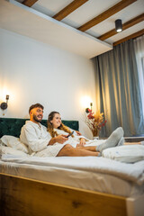 Relaxed Vacation Morning – Couple Watching TV in Bed