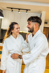 Couple in Bathrobes Looking at Each Other in Hotel Room