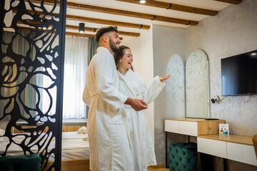 Couple in Bathrobes Admiring Hotel Room Interior